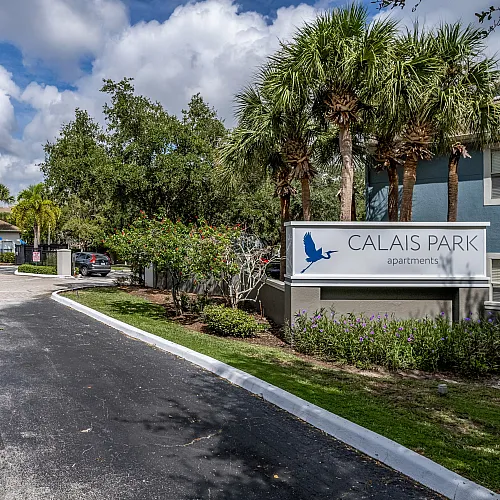 Welcoming entrance to Calais Park Apartments showcasing lush greenery, elegant signage, and inviting landscaping.