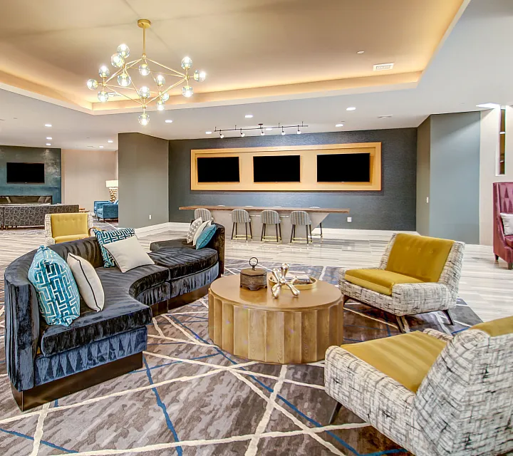 Elegant modern lounge area featuring luxurious seating, stylish geometric carpet, and ambient lighting. Perfect for social gatherings and relaxation.