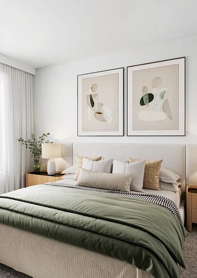 Bright and inviting bedroom with modern decor, large windows offering lush green views, and sophisticated artwork above a cozy bed.