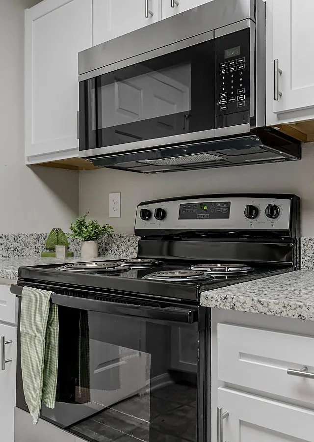 Modern kitchen with sleek stainless steel appliances, elegant granite countertops, and stylish white cabinetry.