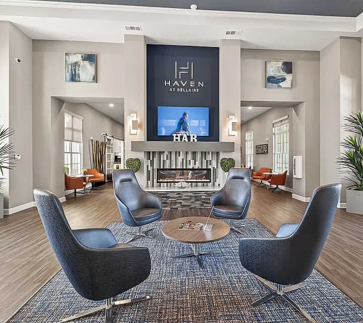 Elegant modern lounge at Haven at Bellaire featuring stylish seating, warm fireplace, and chic decor with natural light.