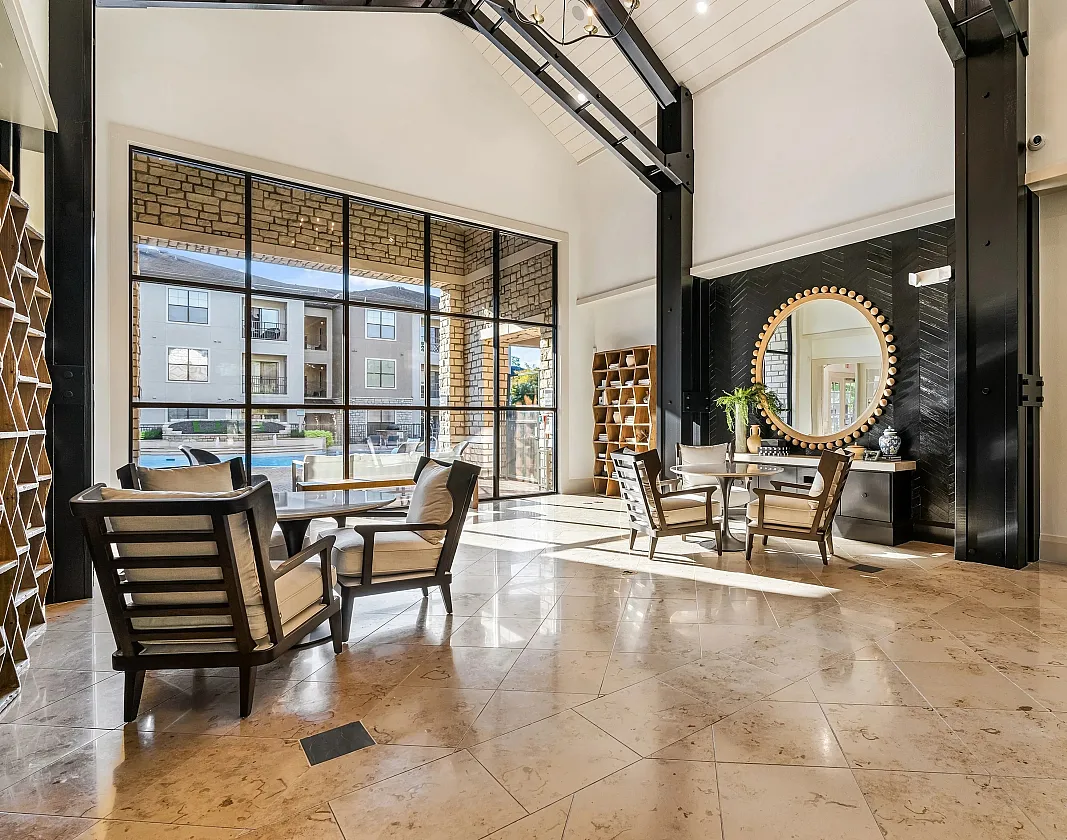 Luxurious open living space with elegant marble floors, ample natural light, and stylish seating, featuring a modern design and picturesque window views.