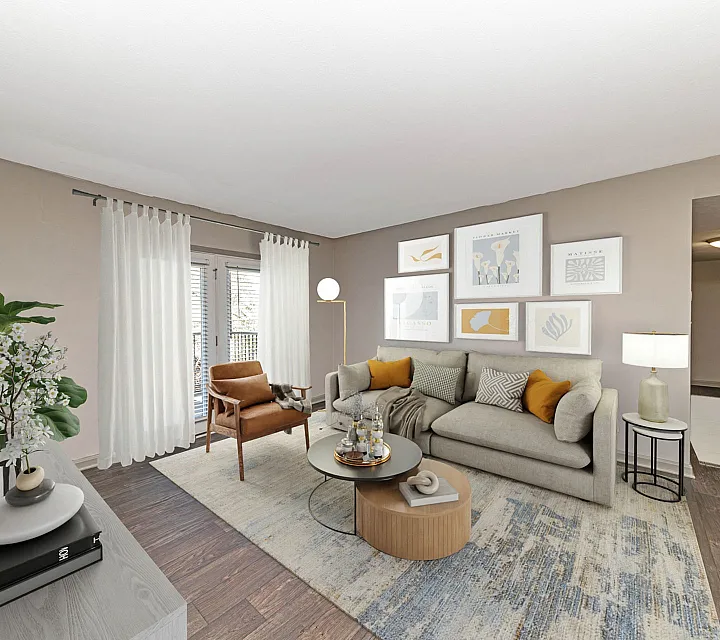 Elegant living room with modern decor, featuring a cozy gray sofa, accent chairs, framed artwork, and warm natural lighting.
