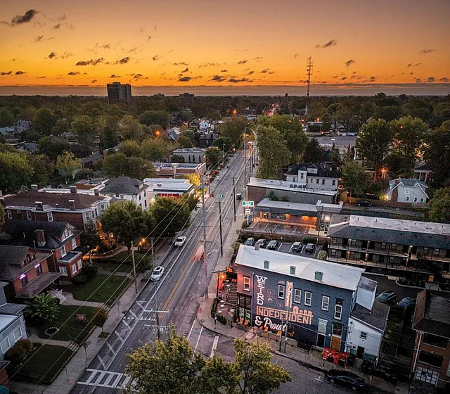 Charming cityscape at sunset showcasing vibrant architecture and tree-lined streets, perfect for an urban living experience.