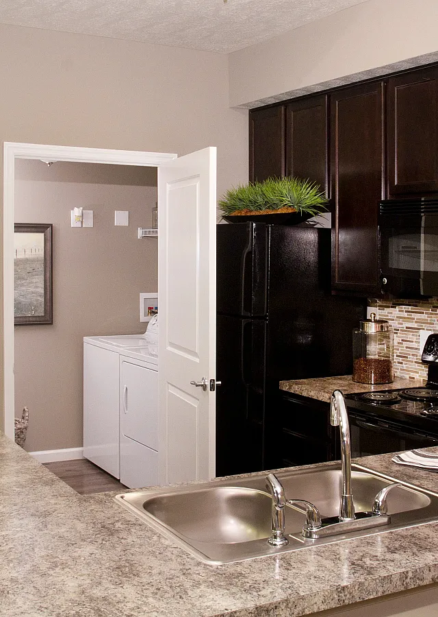 Modern kitchen with sleek dark cabinetry, inviting countertop space, and accessible laundry area.