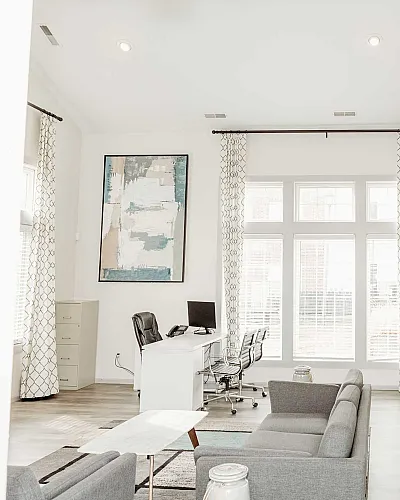 Bright and modern living space with elegant decor, featuring a large window, contemporary artwork, and stylish furniture.
