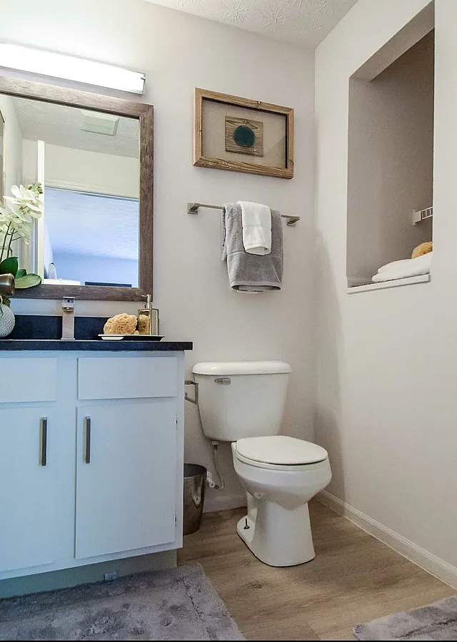 Bright and modern bathroom featuring elegant countertops, sleek fixtures, and a spacious glass shower.