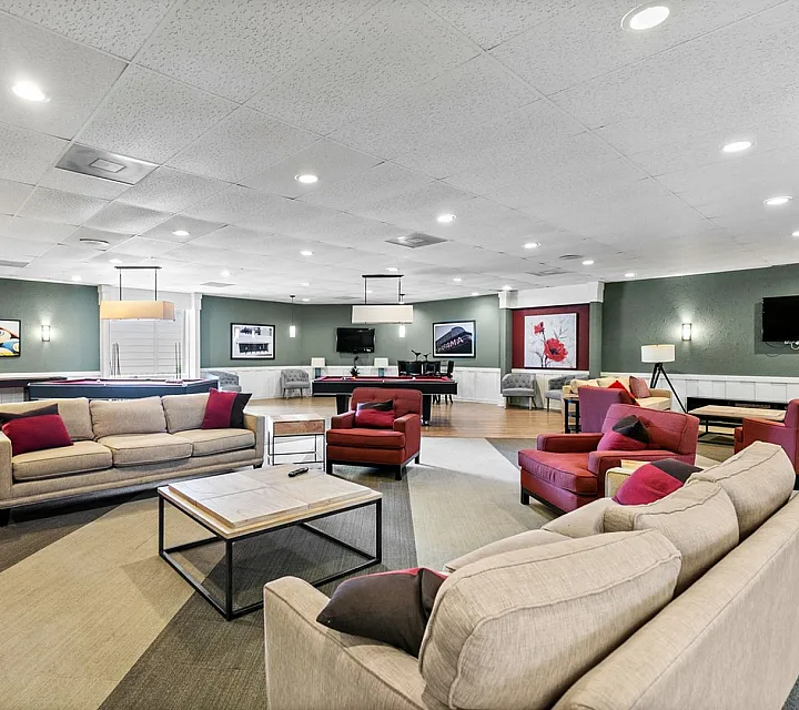 Spacious and inviting recreation room featuring elegant seating areas, a pool table, and contemporary wall decor, ideal for social gatherings and relaxation.