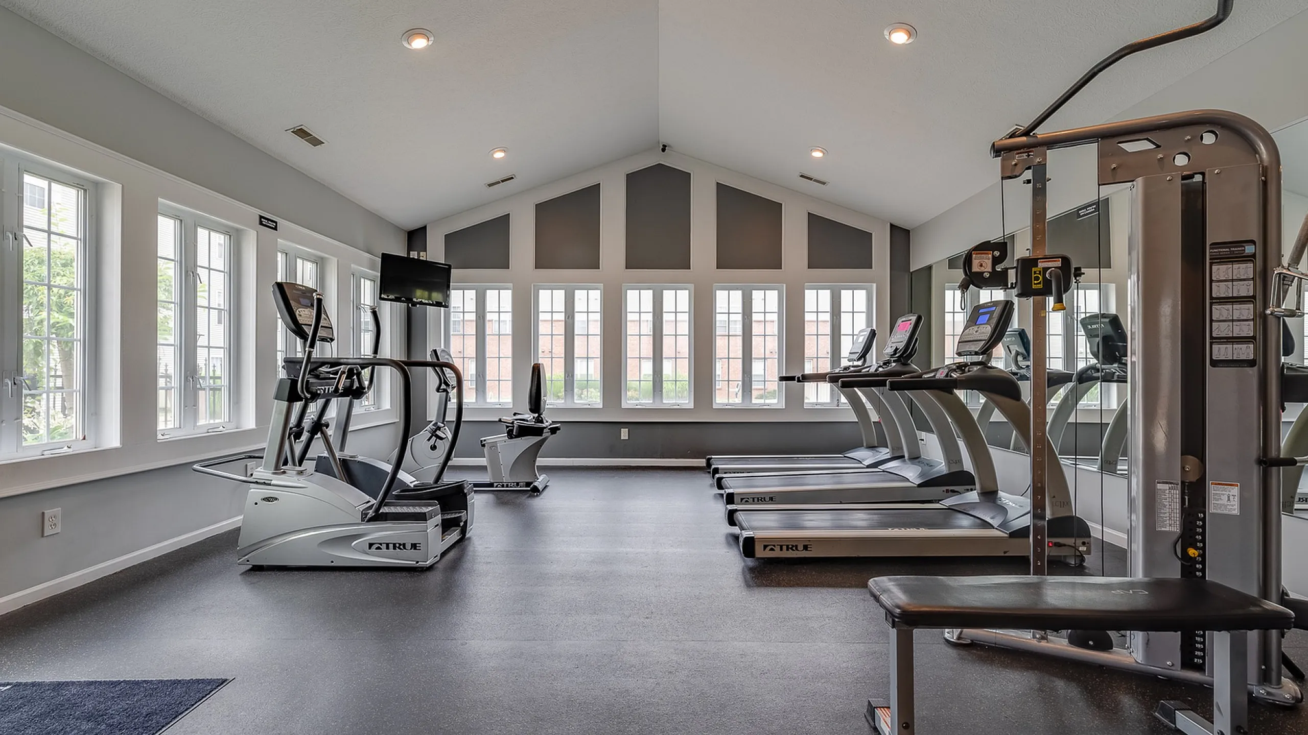 Bright and inviting fitness center featuring modern exercise equipment and large windows for natural light.