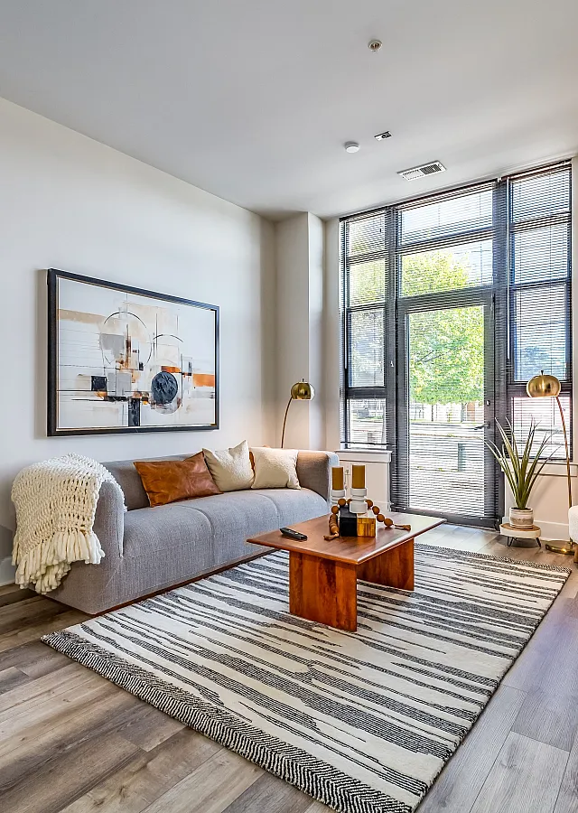 Bright, modern living room with chic decor, large windows, and natural light.