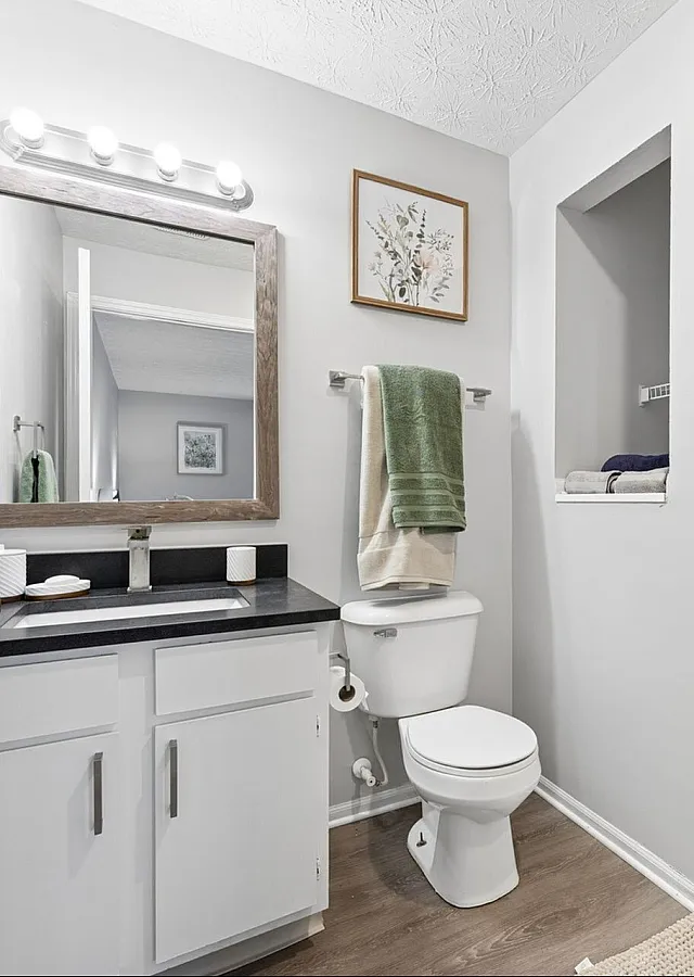 Bright and modern bathroom featuring a sleek vanity, framed mirror, and glass-enclosed shower.