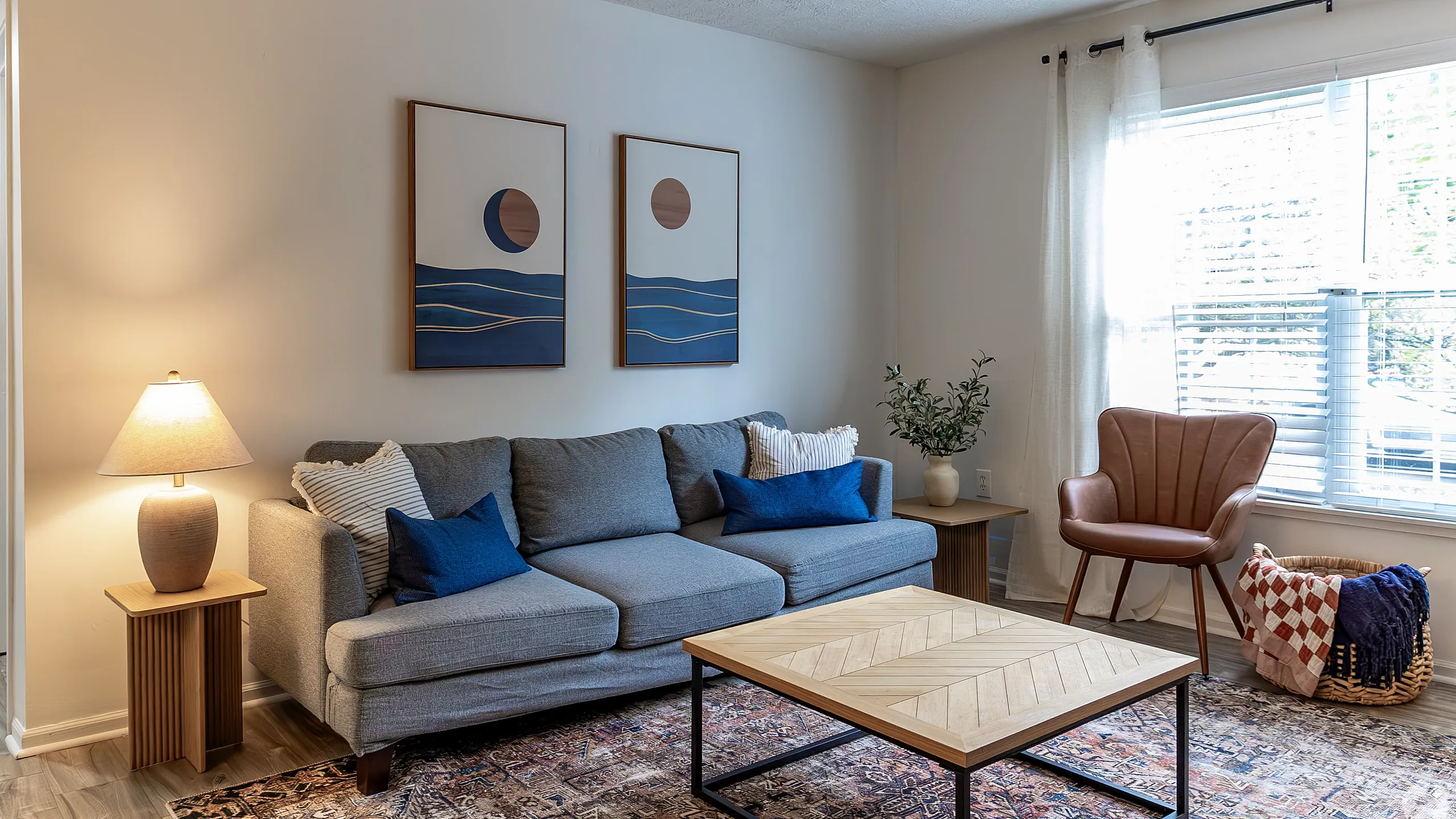 Inviting living room with modern gray sofa, stylish artwork, and abundant natural light.