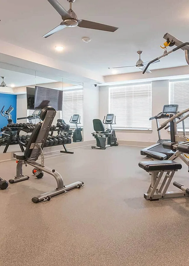 Bright and modern fitness center equipped with state-of-the-art gym machines, free weights, and ample natural light.