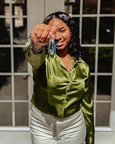 Joyful moment of receiving new home keys, symbolizing new beginnings and modern living in a stylish space.