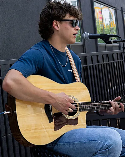 Domain resident and TAMU student playing guitar and singing at Domain's newly renovated resort style pool.
