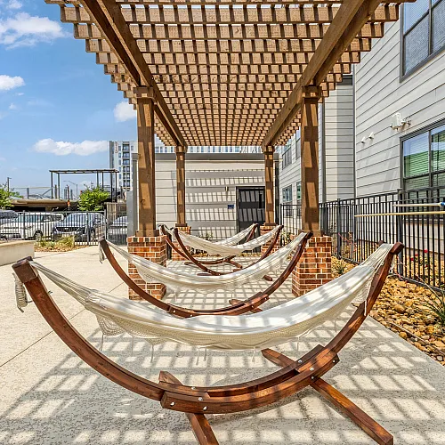 Inviting outdoor space featuring elegant wooden pergola and comfortable hammocks, ideal for relaxation and leisure.