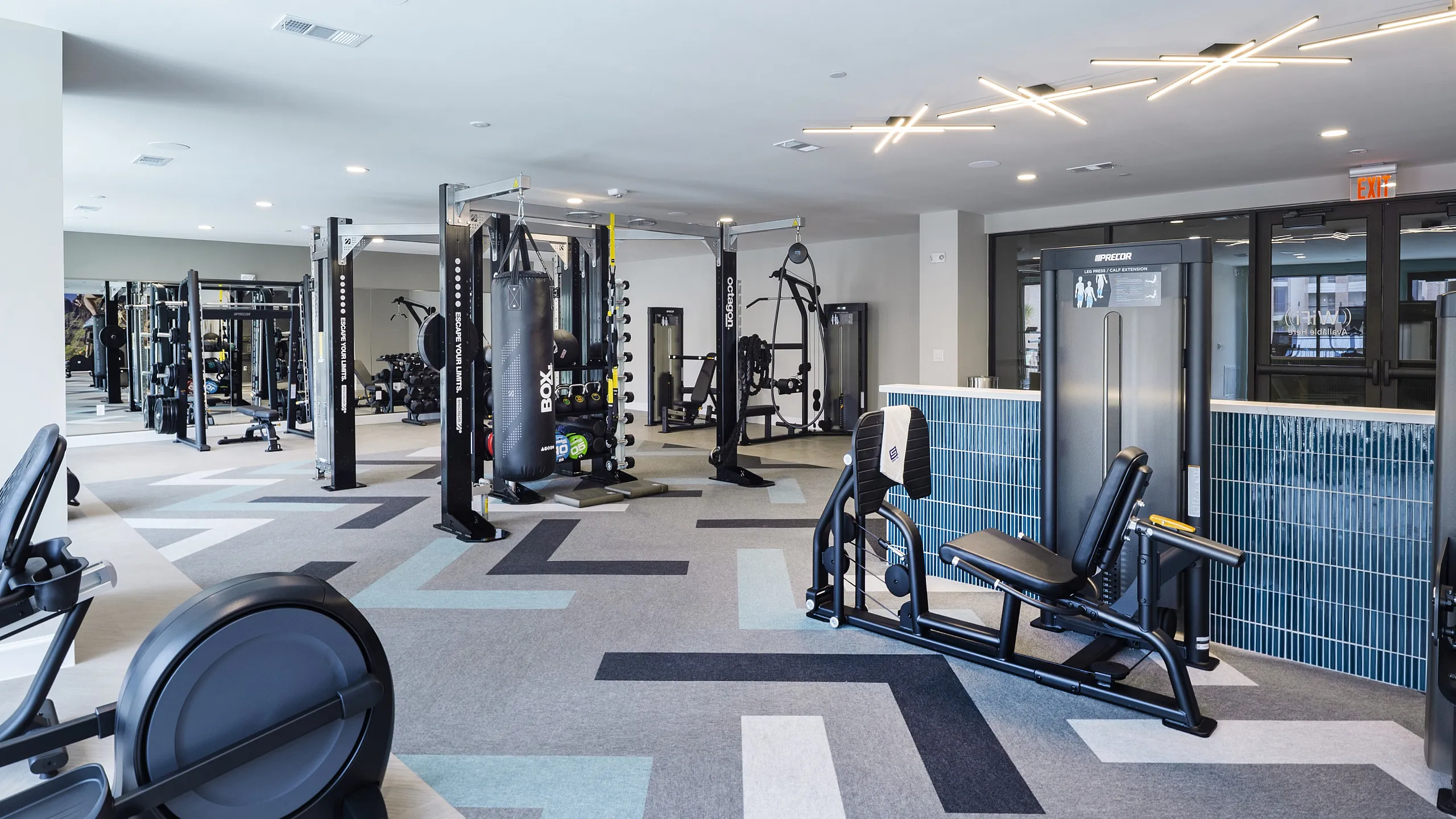 Spacious and modern fitness center featuring cutting-edge gym equipment and stylish lighting.