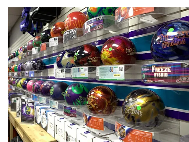 Vibrant display of colorful bowling balls neatly arranged on a wall, showcasing various brands and styles in a modern retail setting.