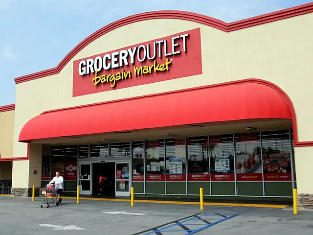 Vibrant storefront of Grocery Outlet featuring bold red signage and inviting entrance.