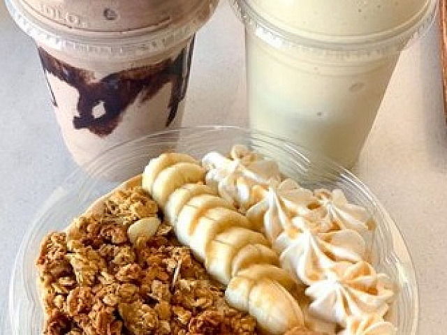 Mouthwatering breakfast spread featuring creamy shakes and a healthy bowl topped with fresh banana slices, crunchy granola, and smooth peanut butter.