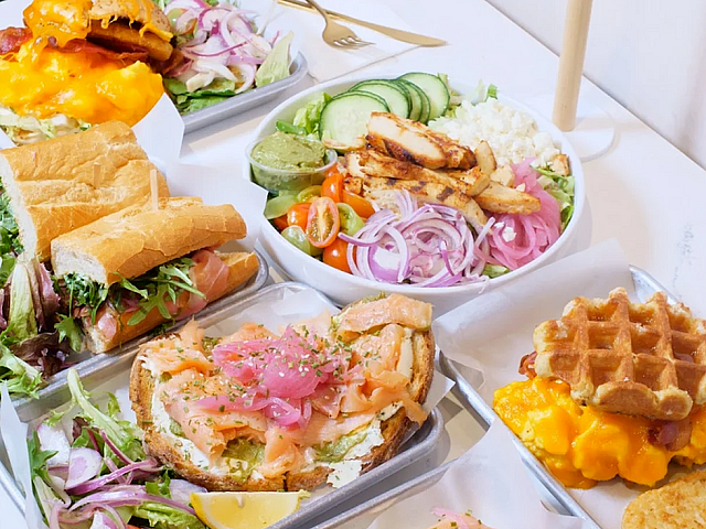 Vibrant and delicious spread featuring gourmet sandwiches, fresh salads with grilled chicken, smoked salmon toast, and savory waffles with melted cheese.
