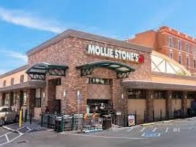 Charming brick grocery store with inviting entrance and ample parking, perfect for fresh shopping experiences.