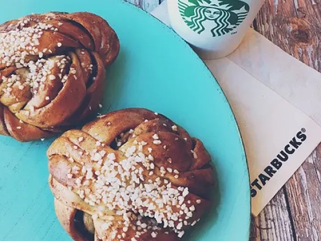 Inviting breakfast scene with scrumptious pastries and a steaming cup of coffee on a rustic wooden table.