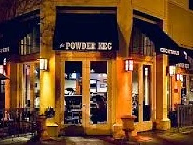 Charming nighttime view of a cozy corner restaurant with inviting outdoor seating and warm lighting.