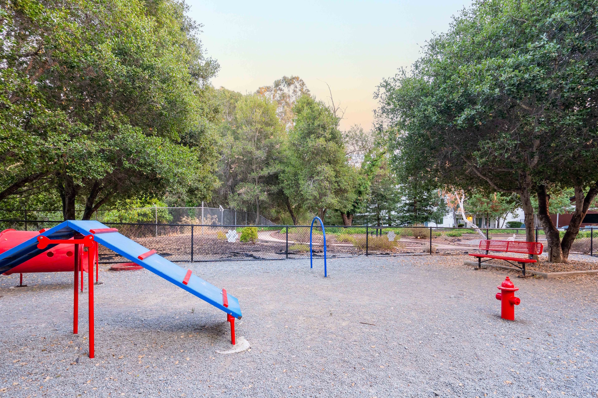 Inviting playground with colorful equipment surrounded by lush greenery.
