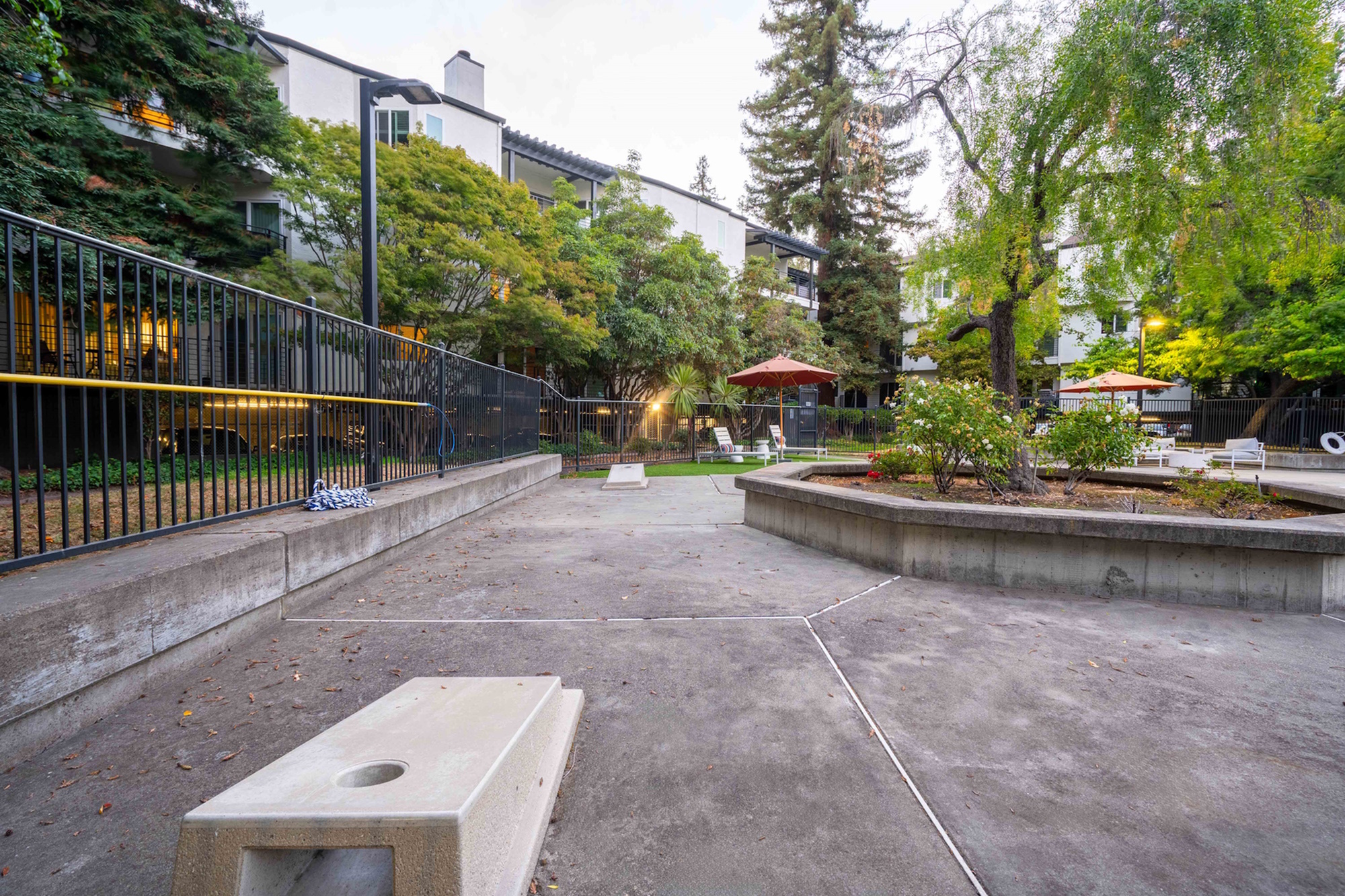 Serene apartment courtyard with lush greenery and outdoor seating