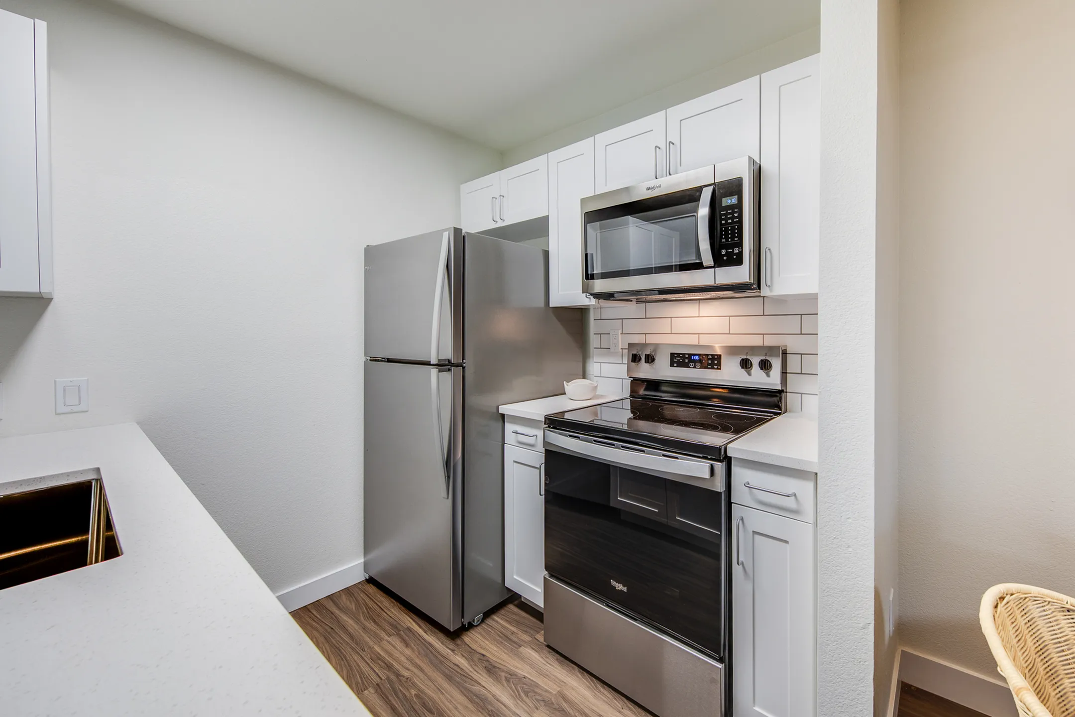 Contemporary kitchen with sleek stainless steel appliances, elegant white cabinetry, and chic subway tile backsplash.