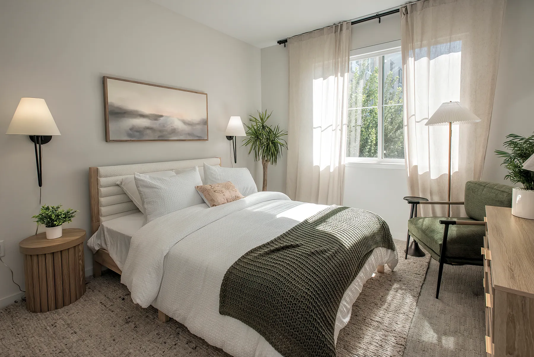 Bright and cozy bedroom with a stylish bed, elegant decor, and a large window letting in natural light.