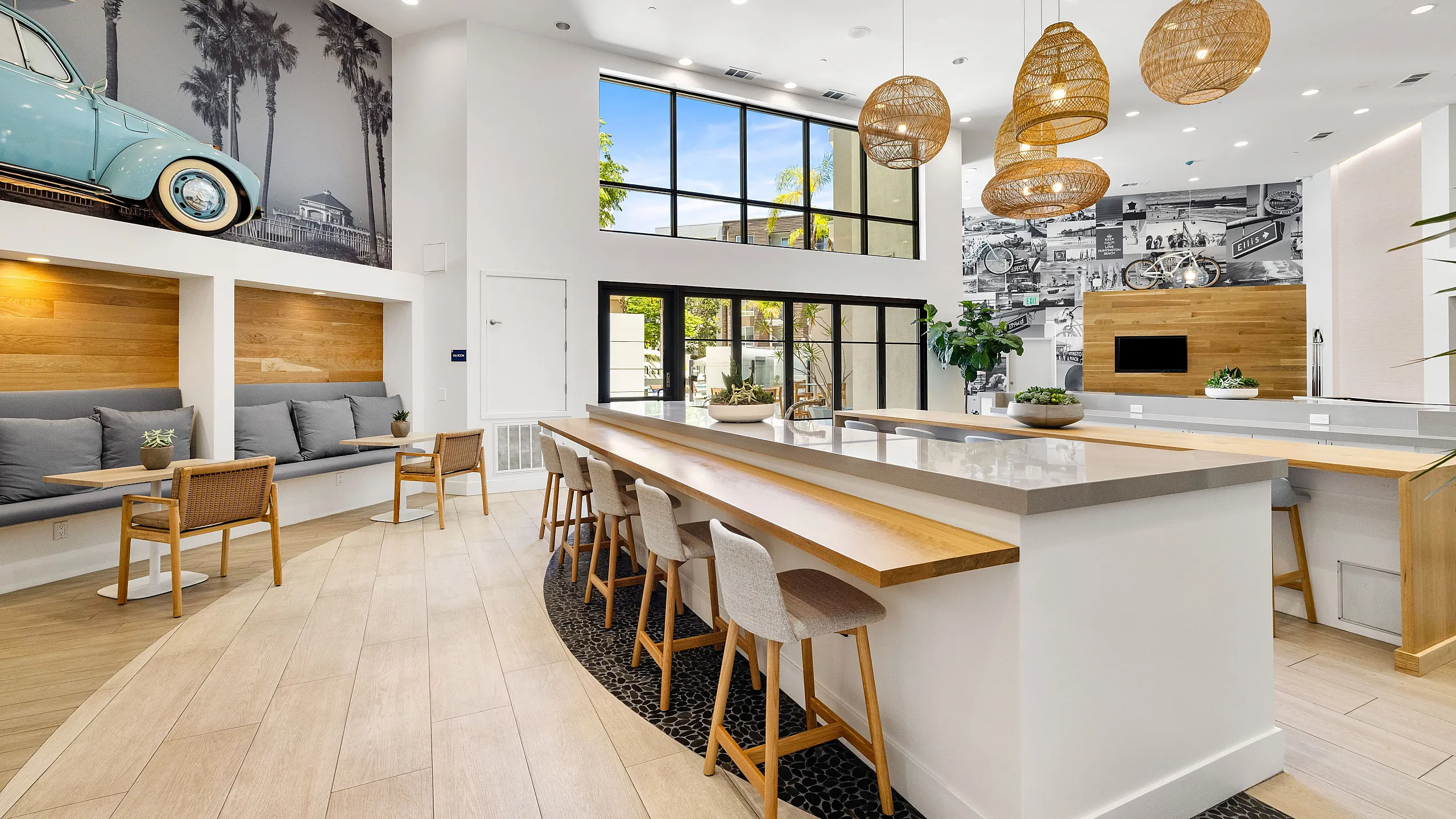 Chic and modern communal kitchen area with expansive windows, stylish seating, and artistic wall decor, perfect for social gatherings.