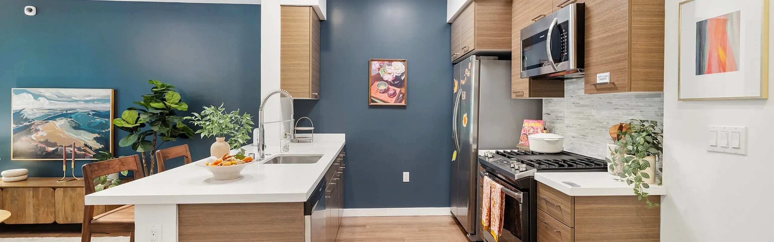 Modern kitchen with sleek wooden cabinets, stainless steel appliances, and a stylish open layout, perfect for entertaining.