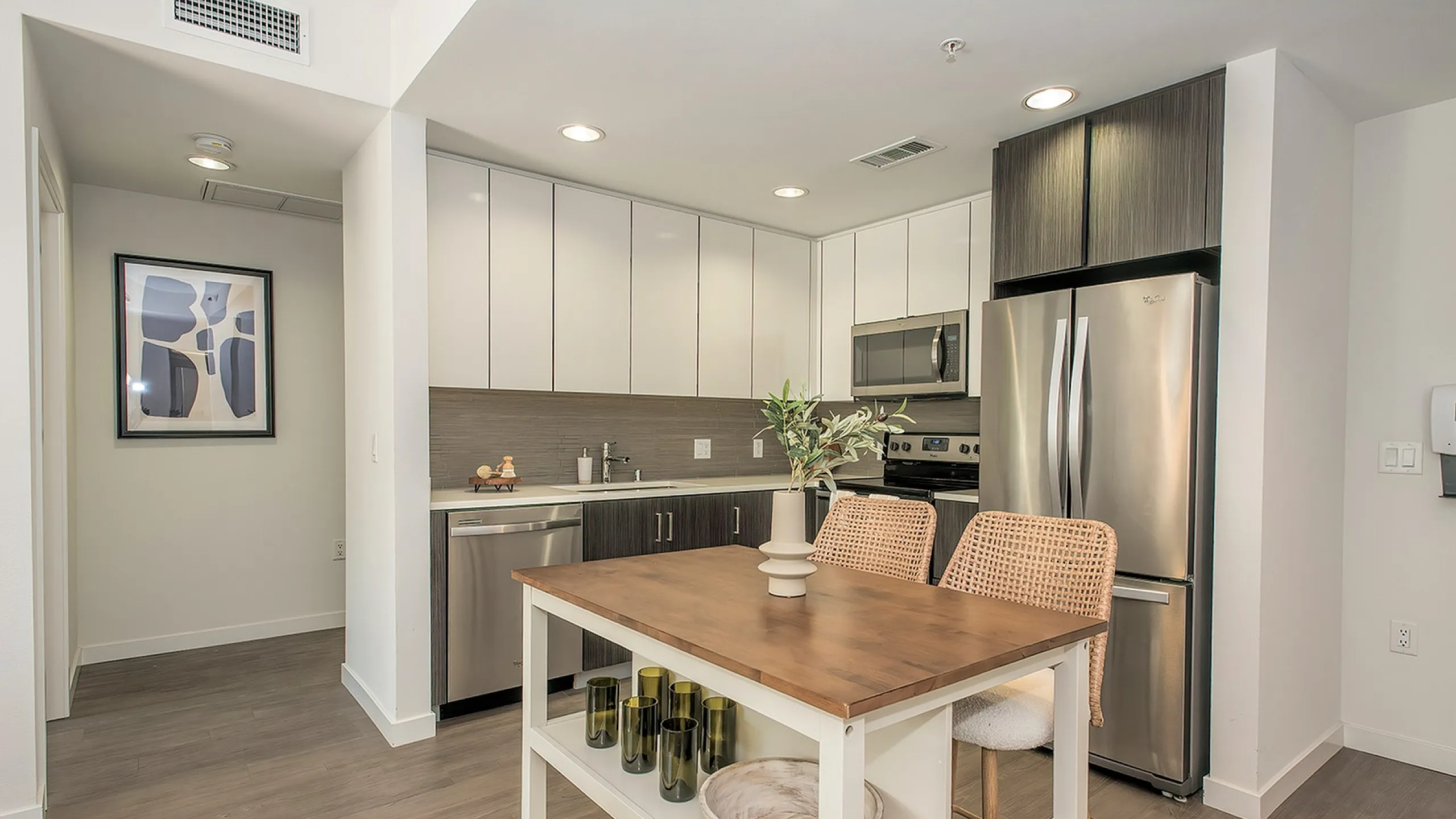 Modern kitchen with sleek stainless steel appliances, elegant cabinetry, and a stylish wooden island, perfect for cozy gatherings and culinary adventures.