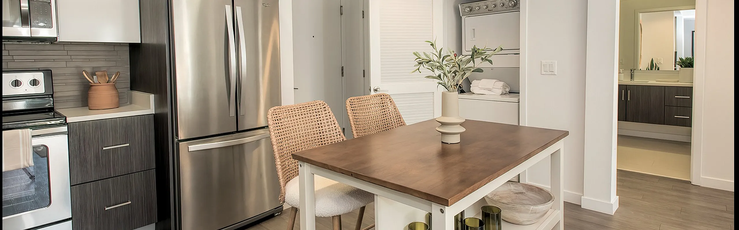 Contemporary kitchen with sleek stainless steel appliances, chic bar seating, and a stylish open layout.