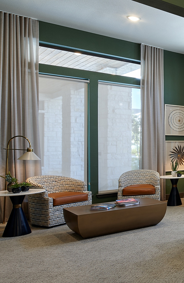 Elegant apartment interior with modern design, featuring a round table, stylish chairs, and cozy lounge area with large windows for natural light.
