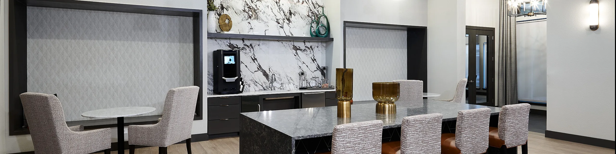 Elegant open-concept kitchen with a stylish marble backsplash, modern lighting, and a large island perfect for entertaining.