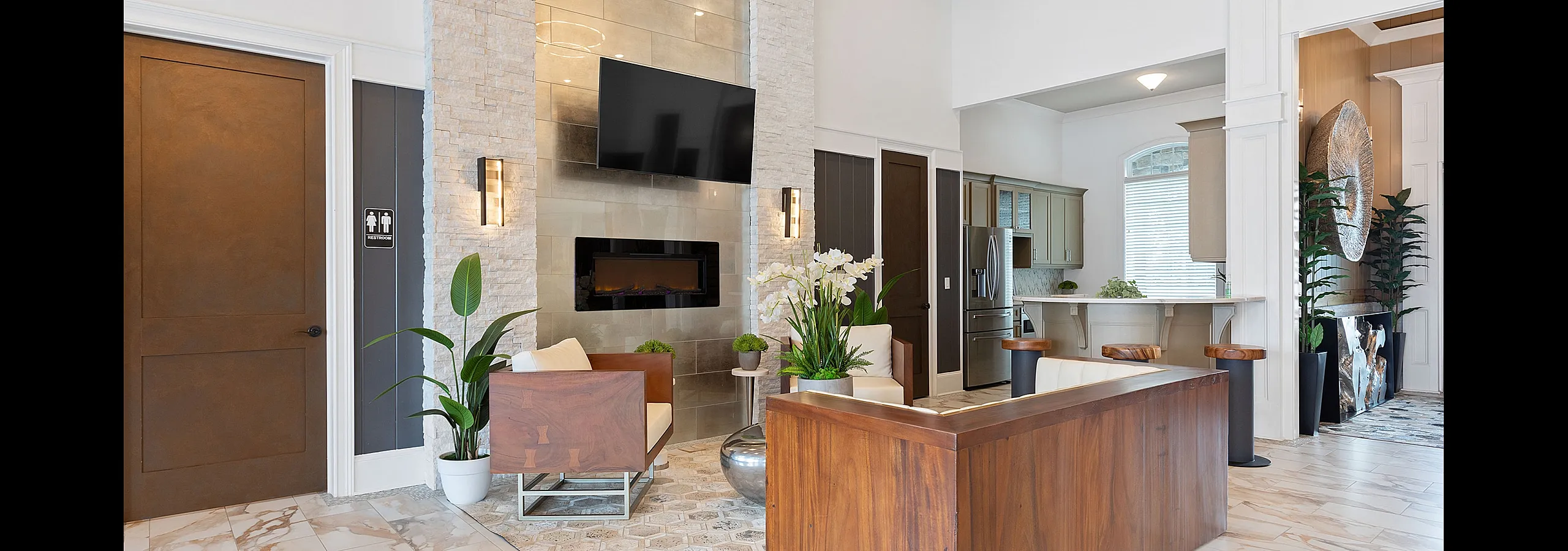 Elegant apartment lobby with modern decor, featuring high ceilings, a stylish lounge area, and a chic kitchenette.