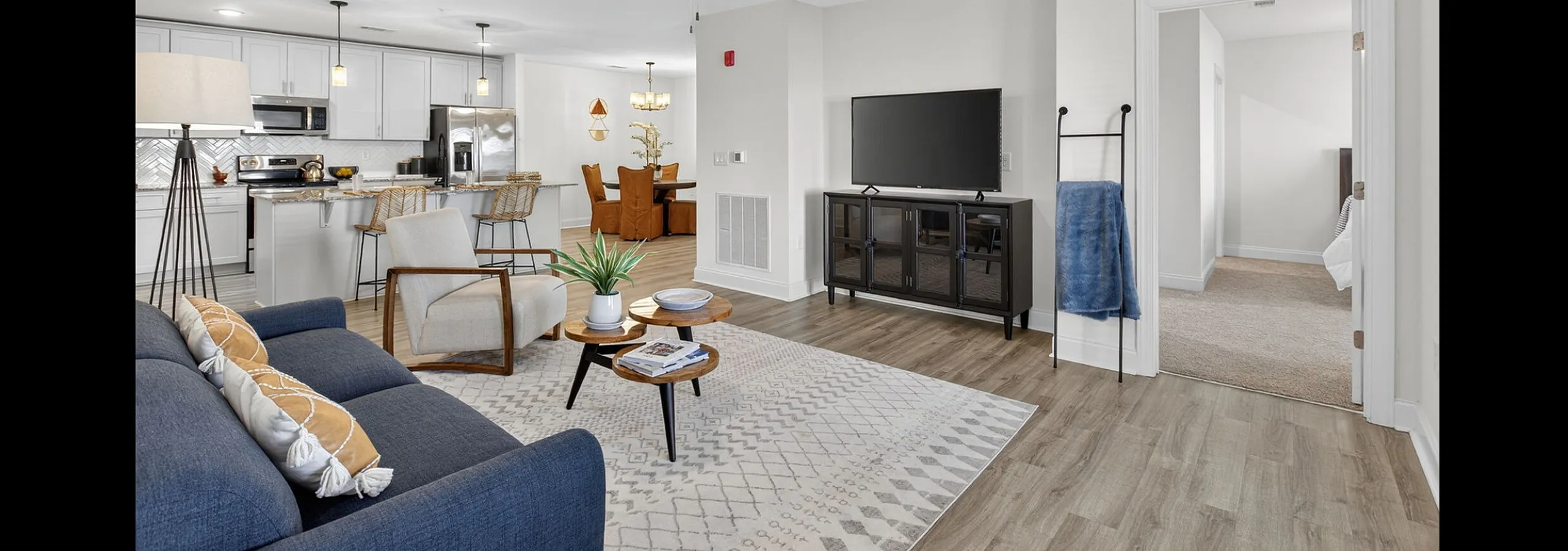 Modern open-concept living area with stylish kitchen and dining space, featuring sleek furnishings and elegant decor.