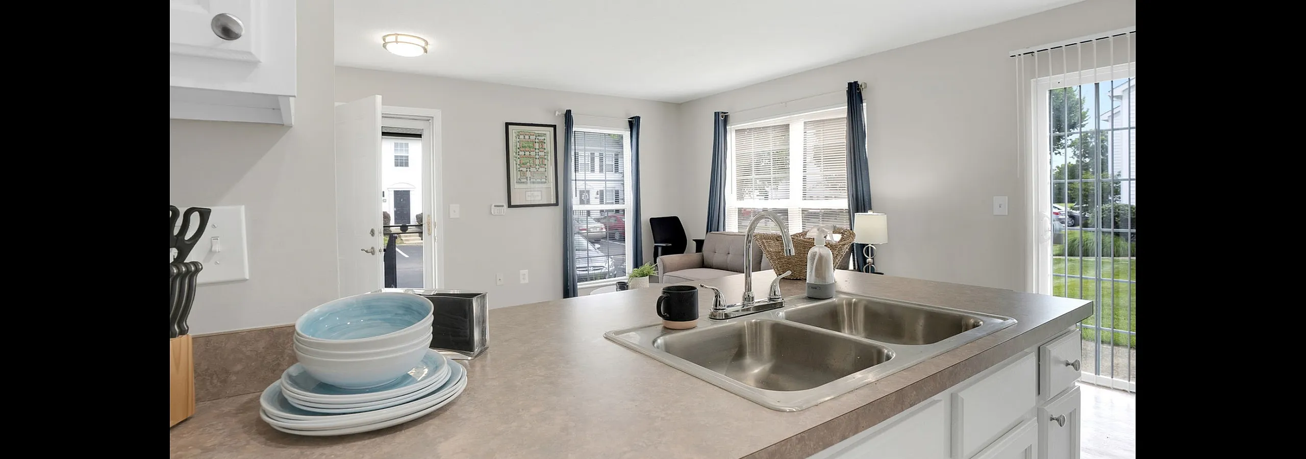 Bright, open kitchen with modern fixtures overlooking a stylish living area, perfect for entertaining.