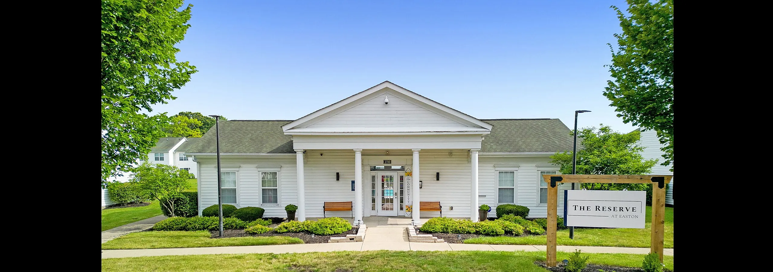 Charming residential building with elegant white exterior and lush landscaping at The Reserve at Easton.