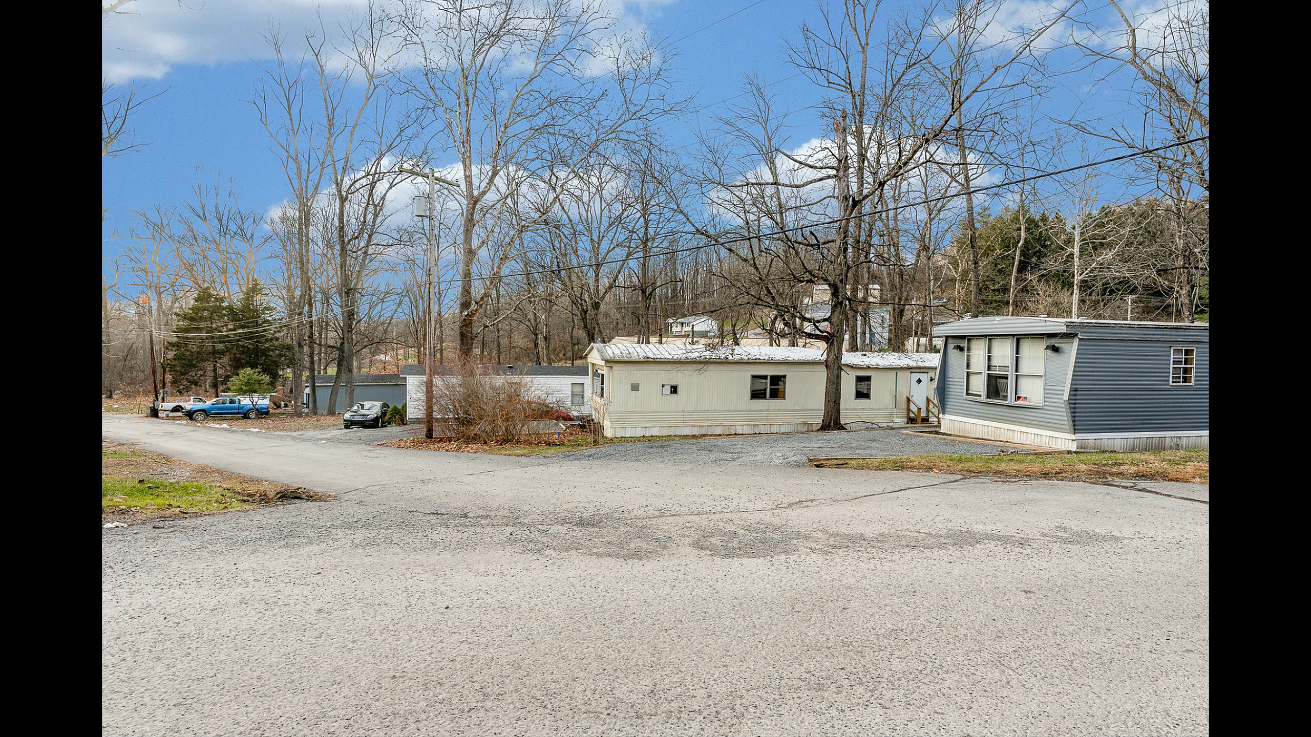 Charming mobile home surrounded by trees, offering a serene and picturesque living environment.