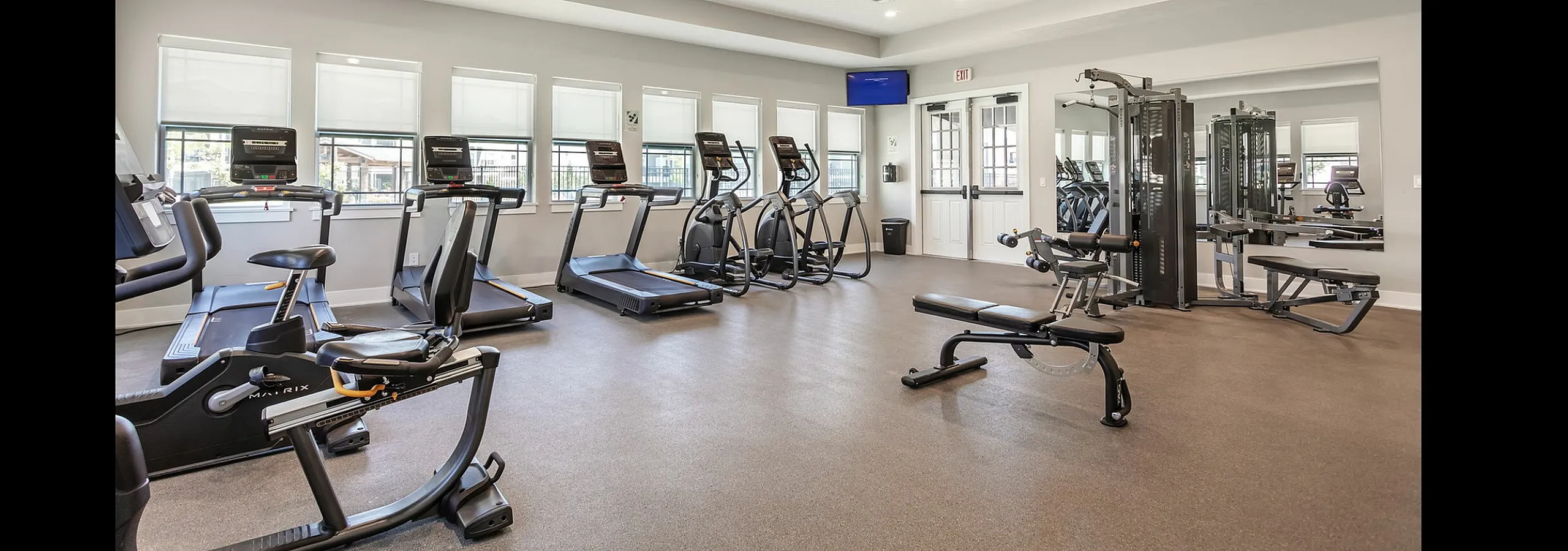 Modern fitness center with state-of-the-art equipment, including treadmills and strength machines, in a bright and spacious setting.