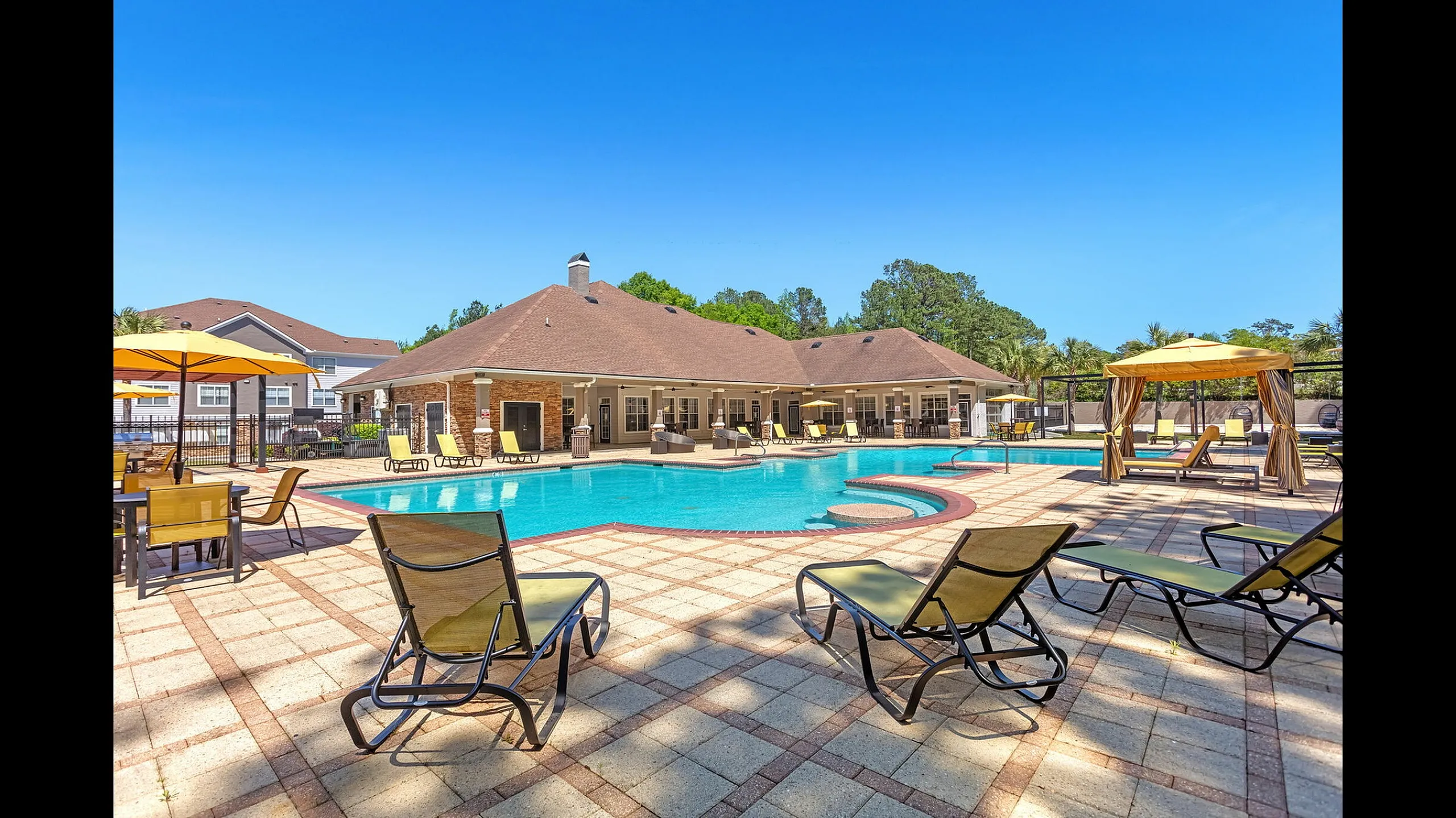 Luxurious apartment pool area with pristine waters, surrounded by stylish lounge chairs and shaded cabanas, perfect for relaxation and enjoyment.