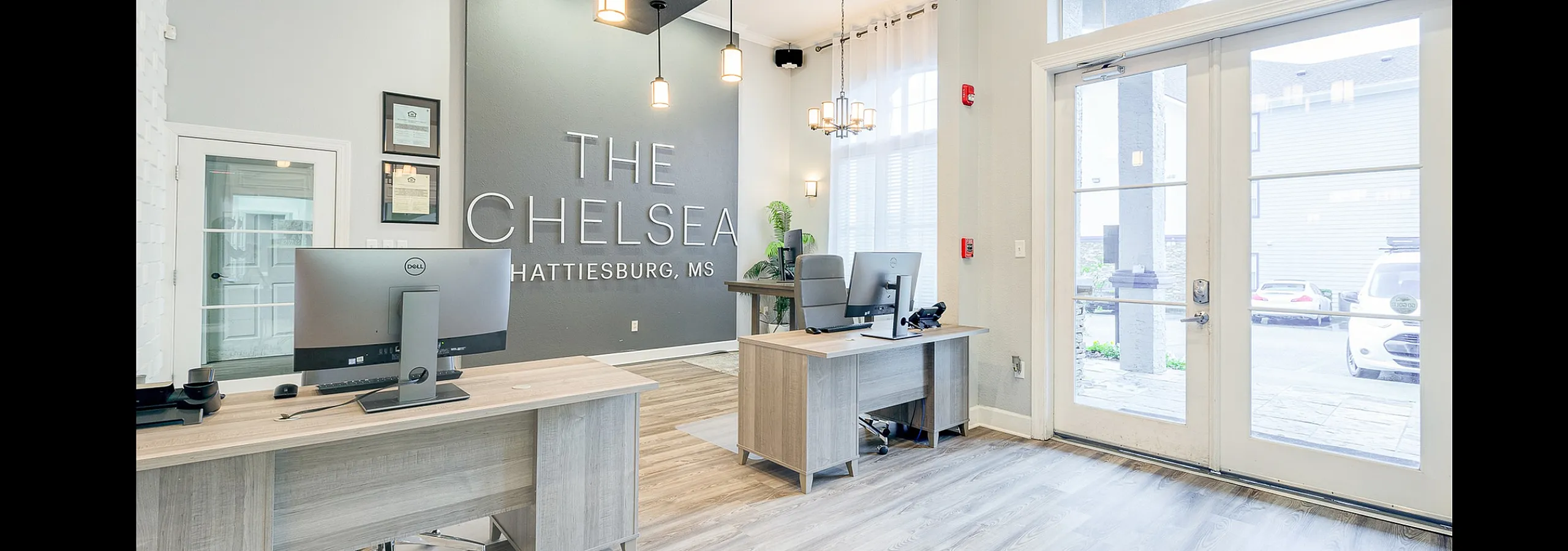 Inviting lobby of The Chelsea in Hattiesburg, MS, featuring modern design, sleek lighting fixtures, and professional workspaces.
