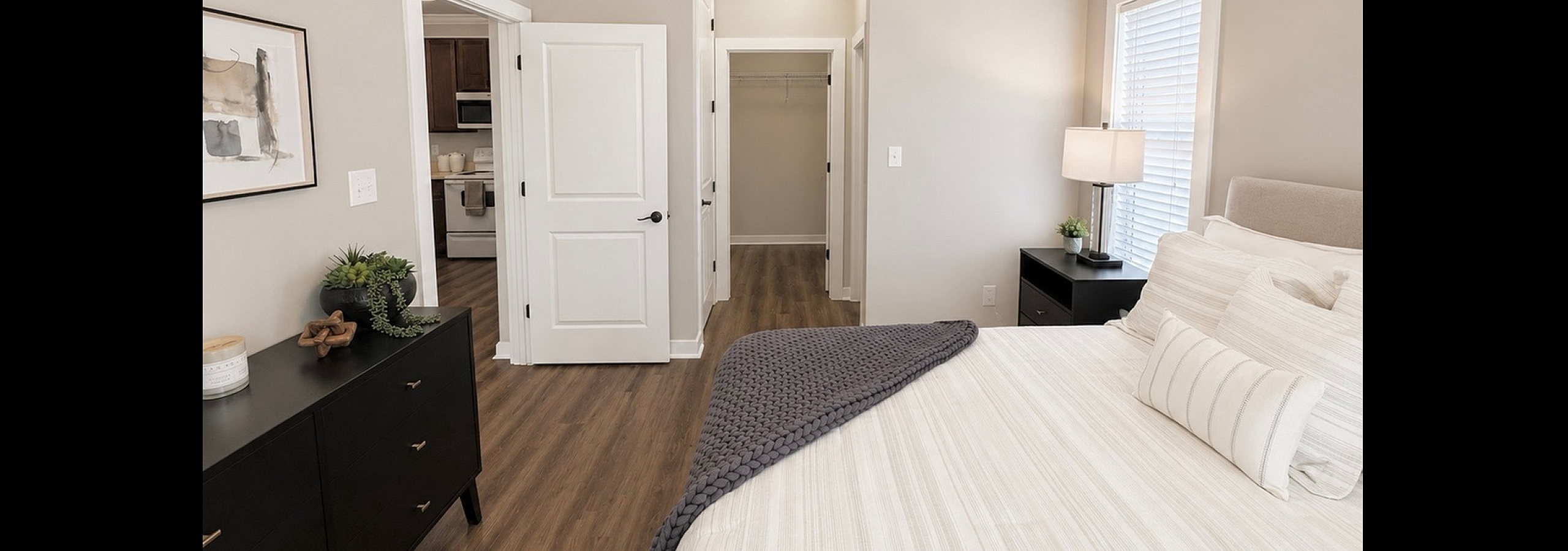 Inviting bedroom with elegant white decor, featuring a cozy bed, modern furnishings, and soft ambient lighting, exuding warmth and comfort.