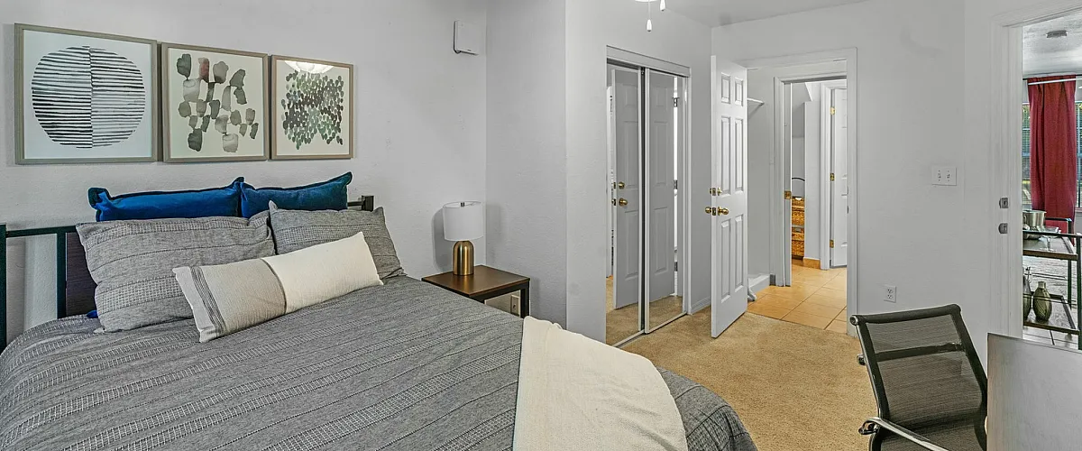 Inviting bedroom featuring a stylish decor with modern artwork, plush bedding, and ample natural light.