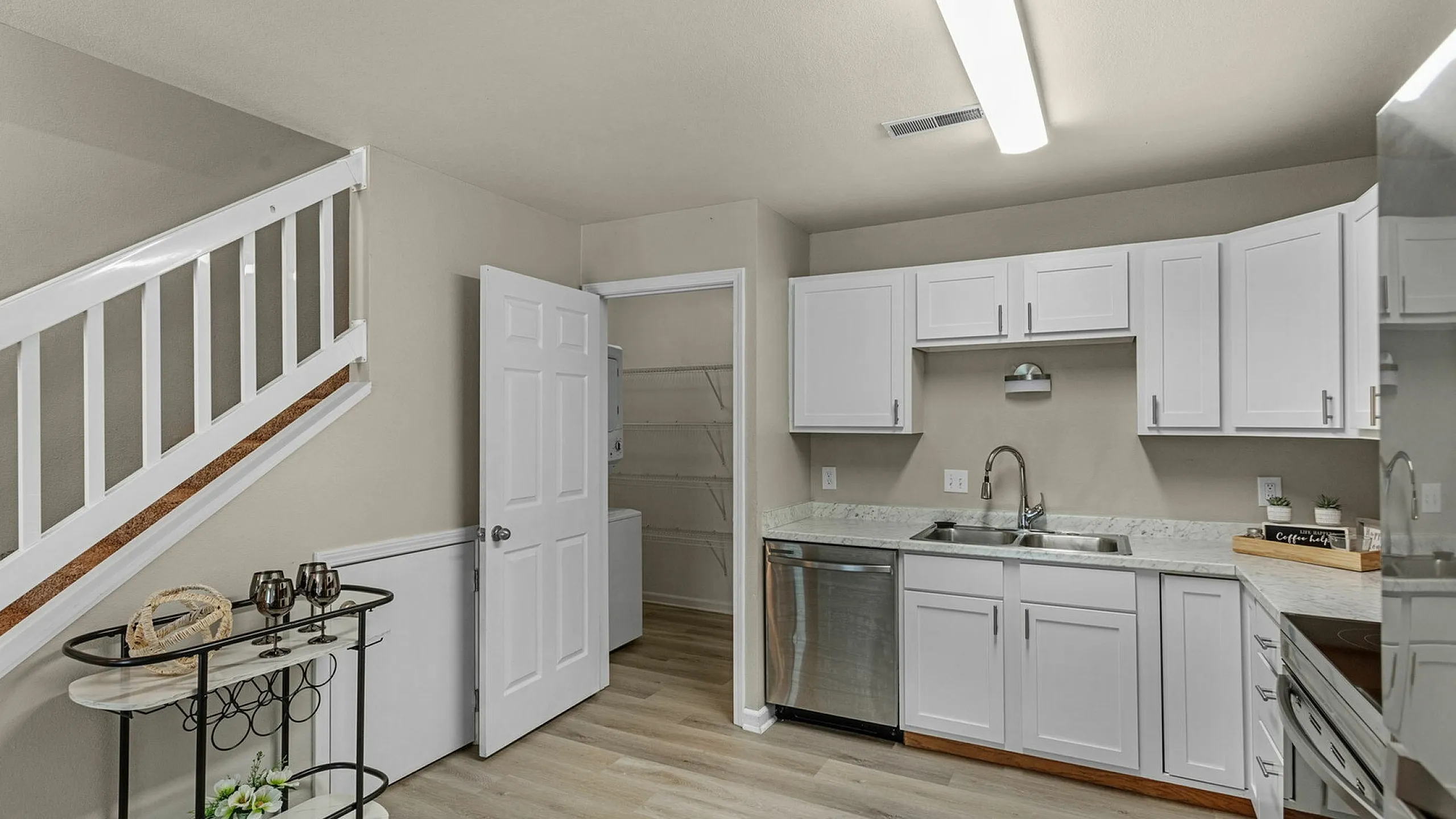 Renovated kitchen with white cabinets and stainless appliances