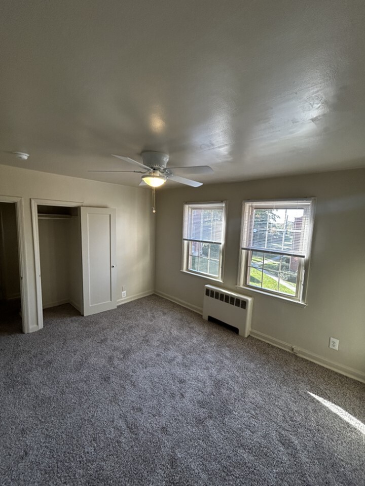 Bright and airy bedroom with large windows, plush carpeting, and ample closet space.